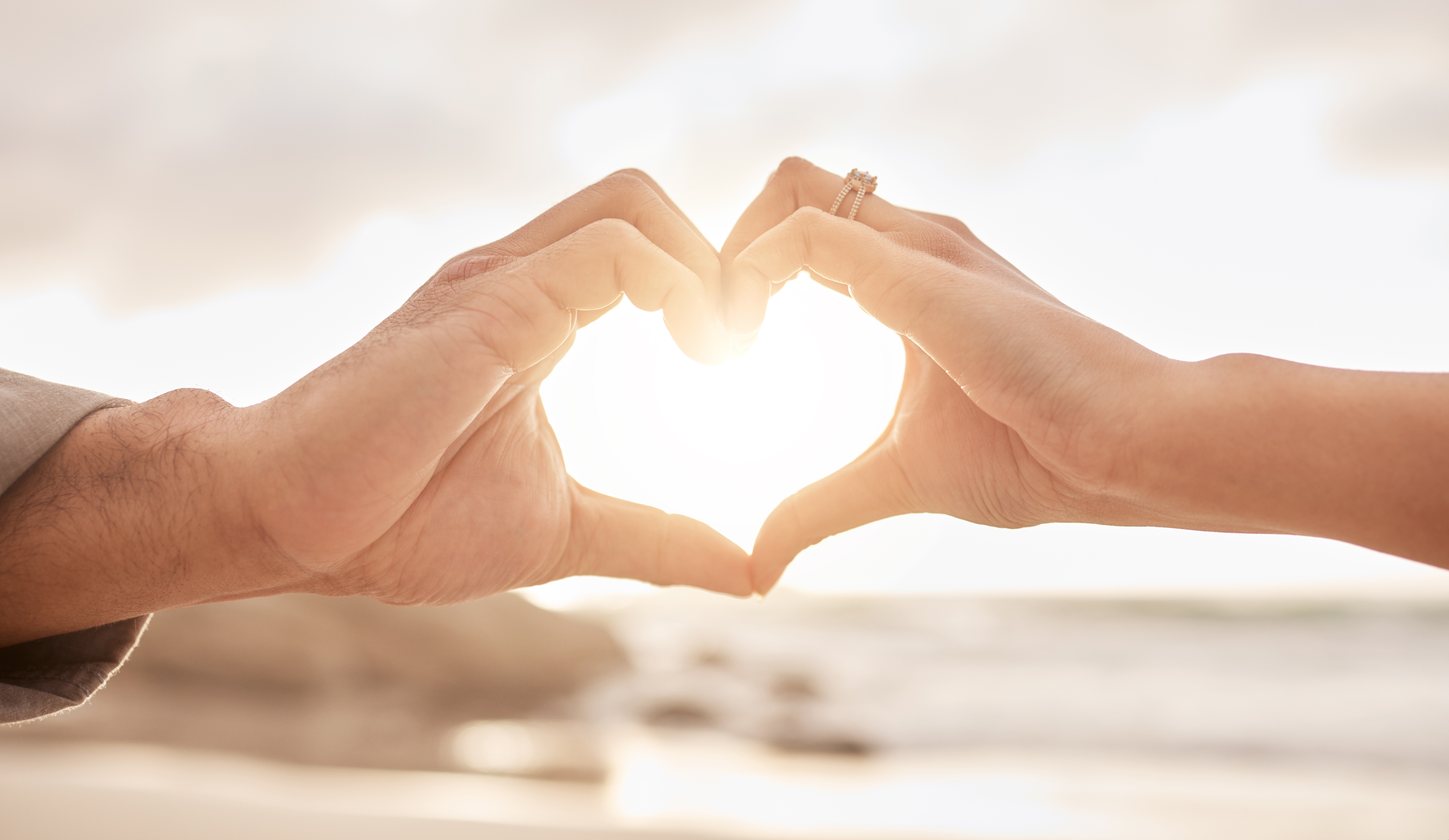 Couple,,hands,and,heart,by,sunset,with,love,on,beach